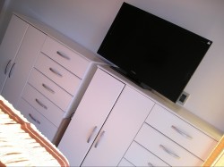 TV LED 32''. Dos chifonier con cajones y espacio para colgar.